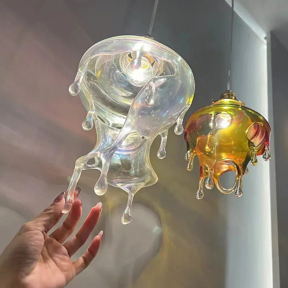 Glass jellyfish-shaped lamps with a hand for scale