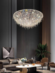 Luxurious chandelier hanging in a modern living room with a dark wall and gray sofa.