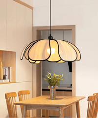 Modern pendant light hanging above a dining table with a neutral background