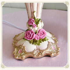 Decorative item with pink roses and gold detailing on a pink background