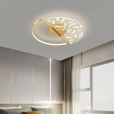Gold and white circular ceiling light with feather pattern glass shade and gold frame, mounted on a grey ceiling.
