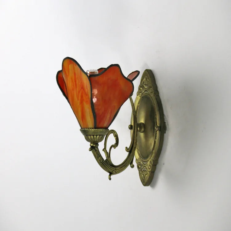 Decorative wall sconce with a red glass shade on a white background