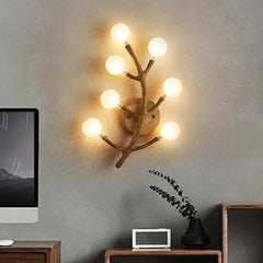 Wall-mounted light fixture with multiple bulbs on a gray wall.