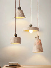 Four natural stone pendant lights with cord mounts hanging against a white wall