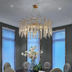 Luxury chandelier hanging above a dining table with floral arrangements.