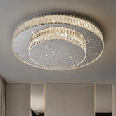 A modern, multi-tiered circular flush mount ceiling light fixture with numerous faceted crystals arranged around two concentric rings, set against a neutral ceiling background.