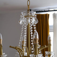 Close-up of a chandelier with crystal accents in a room with curtains.