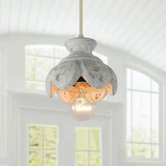 Close-up of a wood carved floral pendant light fixture showcasing the distressed finish and exposed bulb.