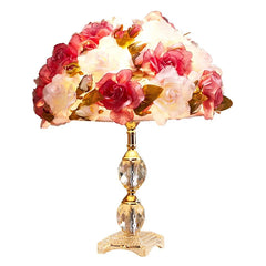 Decorative table lamp with floral shade and crystal base on a white background