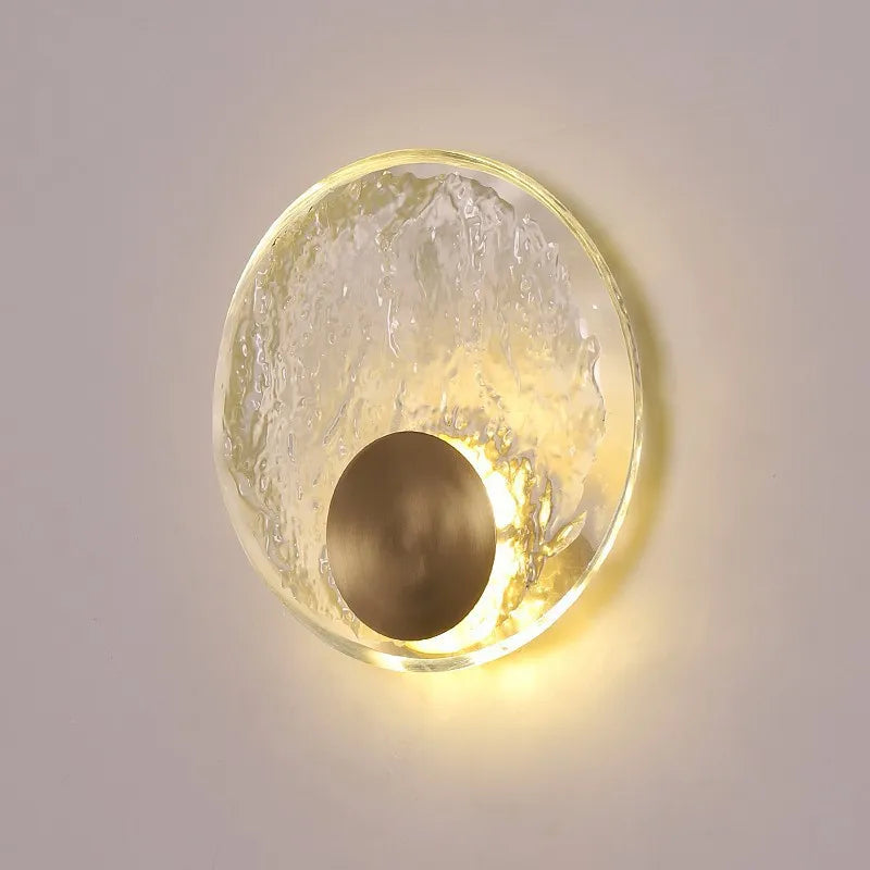 Round wall light fixture with textured glass shade on a neutral background