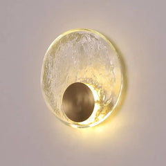 Round wall light fixture with textured glass shade on a neutral background