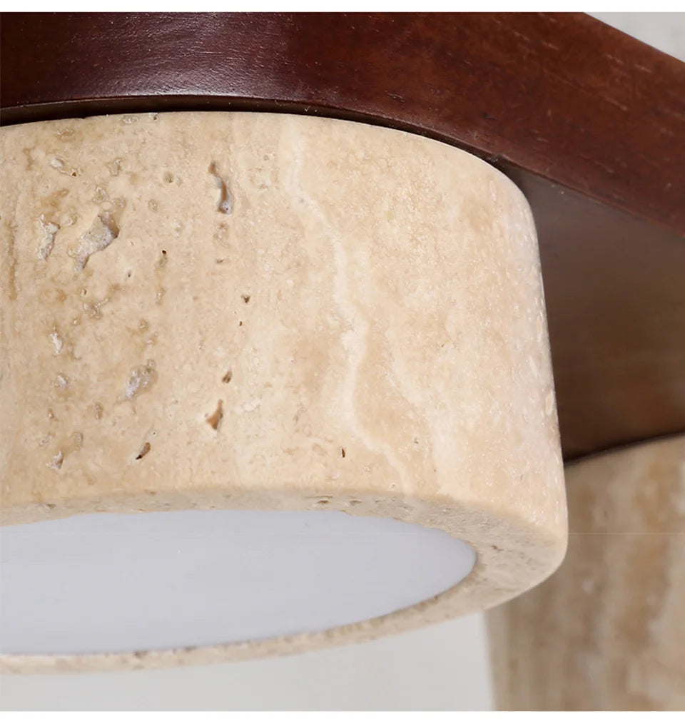 Close-up view of the textured travertine stone shade and solid wood fixture of the linear flush mount ceiling light.