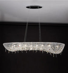 Close-up of an oval crystal chandelier with colorful accents hanging above a table.