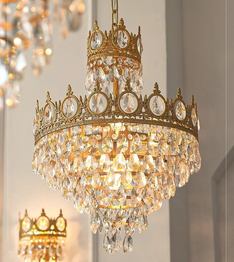 Gold chandelier with crystal accents on a neutral background