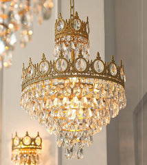 Gold chandelier with crystal accents on a neutral background