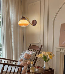 Cozy living room with a teddy bear, wine glass, and flowers on a wooden table.