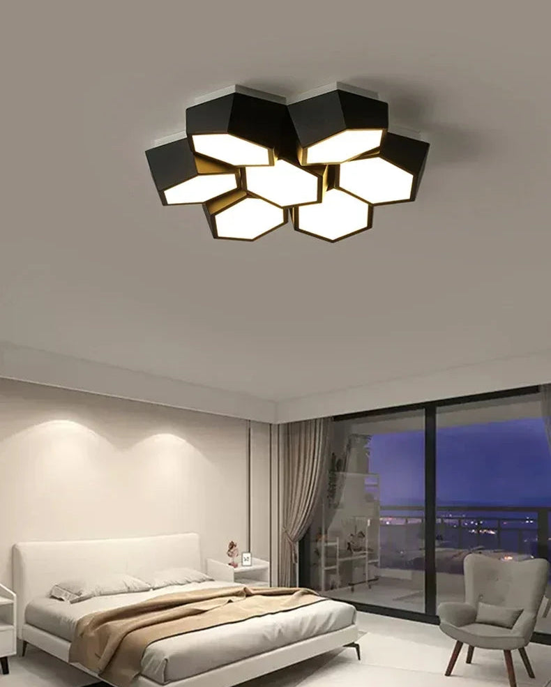 Modern ceiling light fixture in a bedroom with a view of the city at night.