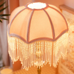 Decorative lamp with fringe details on a blurred background