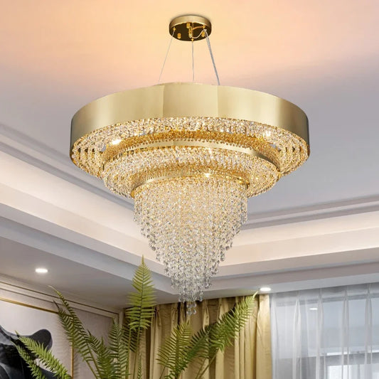 A luxurious gold tiered chandelier with cascading crystals, illuminated against a ceiling.