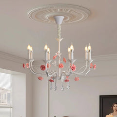 White floral crystal candelabra chandelier with pink roses installed on a white ceiling with decorative molding.