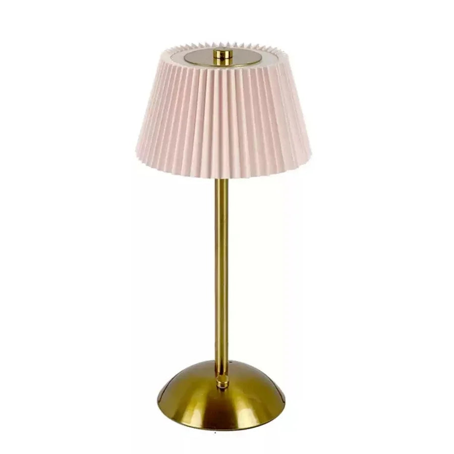 Table lamp with pink pleated shade and gold base on a white background