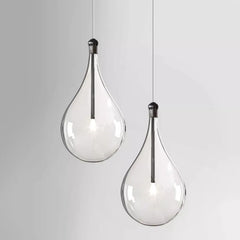 Two clear glass teardrop pendant lights hanging against a white background.
