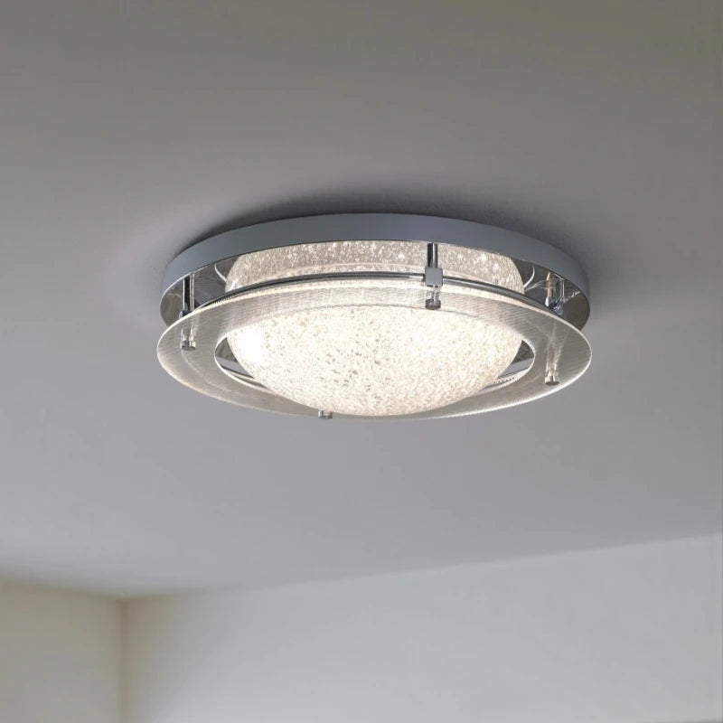 Side view of a chrome flush mount ceiling light, showing its rounded profile against a white ceiling.