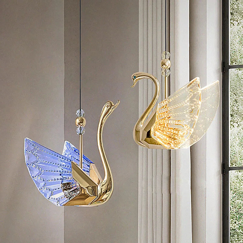 Decorative wall lights shaped like swans with gold and crystal accents on a neutral wall.
