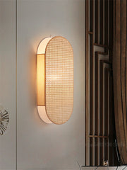 Modern wall light fixture on a neutral wall with decorative elements.