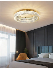 Gold ring crystal ceiling light fixture installed in a bedroom, providing ambient lighting.