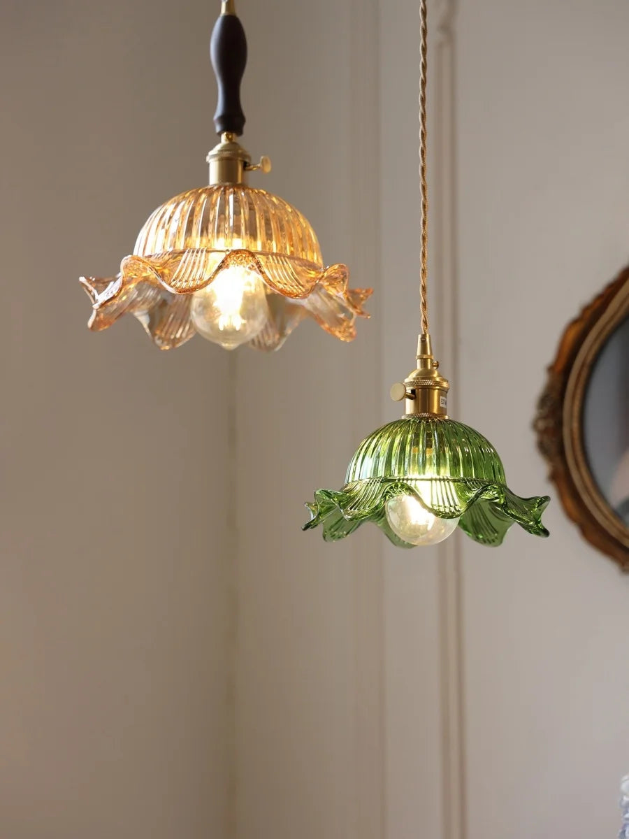 Two decorative pendant lights with glass shades hanging against a neutral wall.