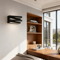 Modern home office with wooden desk, bookshelf, and wall-mounted light fixture.