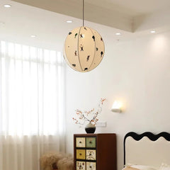 Decorative pendant light in a bedroom setting with a cabinet and window.