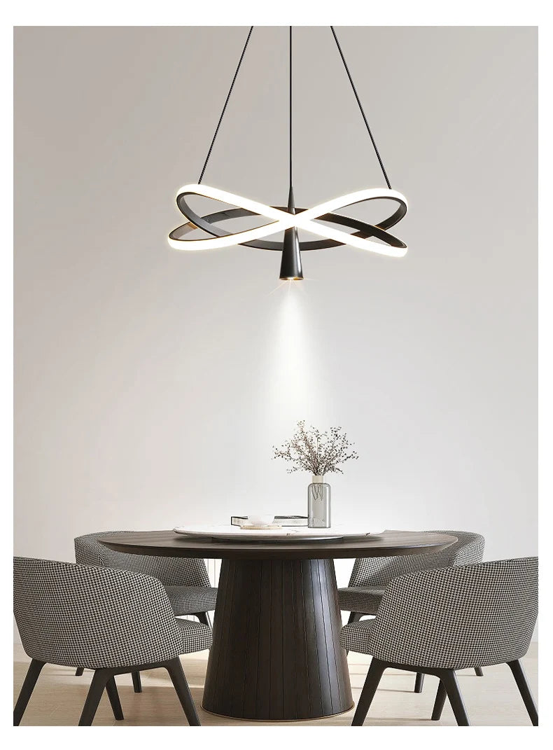 Modern dining room with a round table and chairs, featuring a stylish pendant light.
