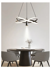 Modern dining room with a round table and chairs, featuring a stylish pendant light.