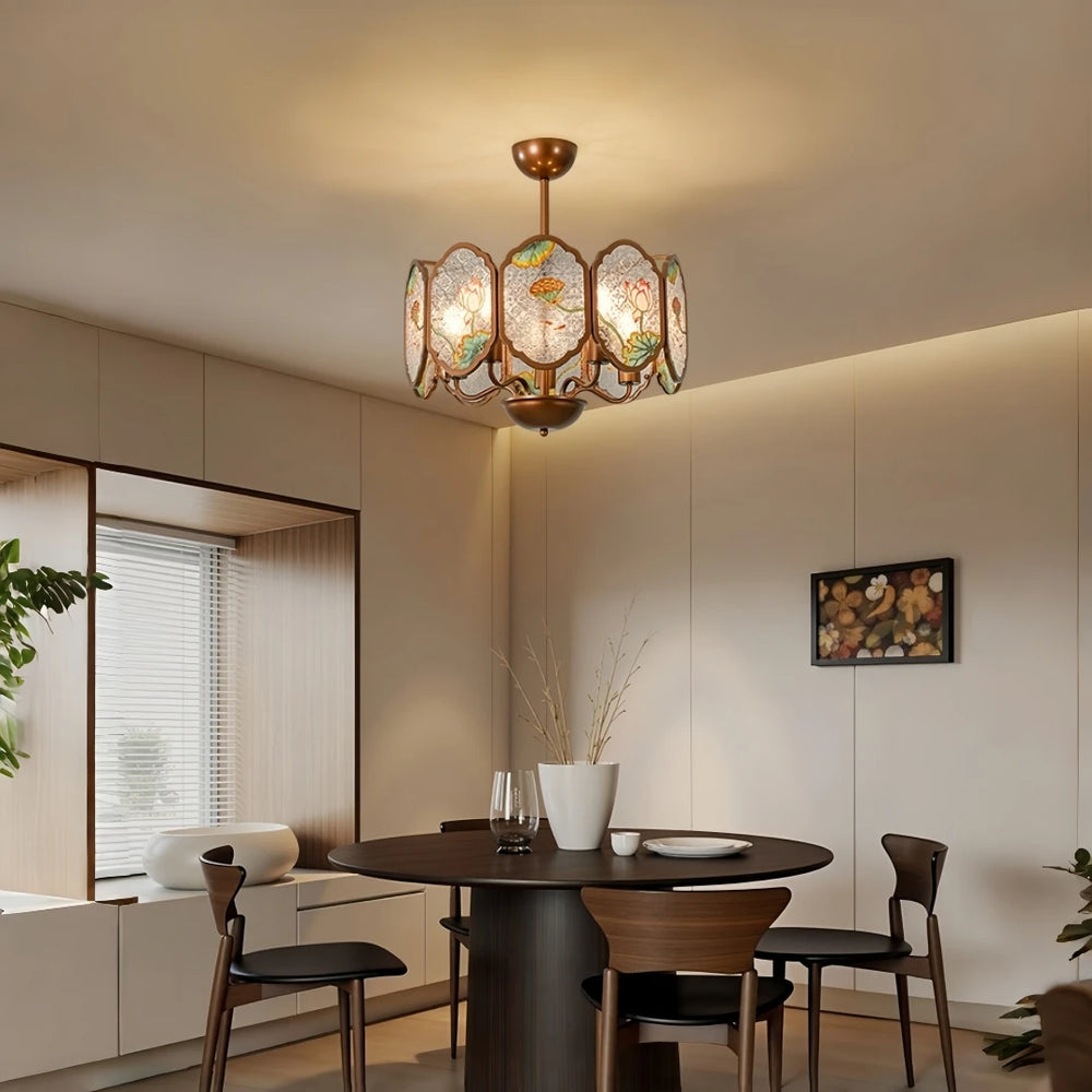 Copper frame chandelier with floral acrylic panels over a round dining table.