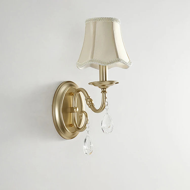 Wall-mounted light fixture with beige lampshade and crystal accents on a plain background