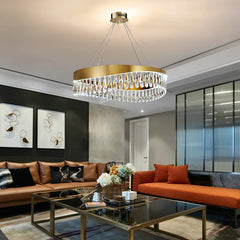 Modern living room with a chandelier, brown sofa, and orange chair.
