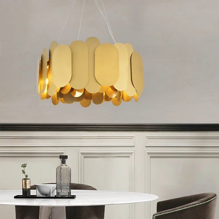 Gold oval link chandelier above a dining table with a bottle of wine
