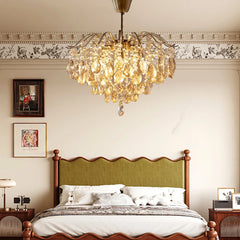 Chandelier hanging above a bed in a bedroom with decorative wall art.