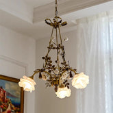 Brass floral pendant light with clear glass rose-shaped shades hanging from a chain.