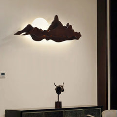 Decorative wall light fixture on a wall with a sculpture below.