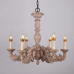 Close-up of a distressed wood chandelier with candelabra-style arms, intricate carvings, and detailed floral accents against a white background.