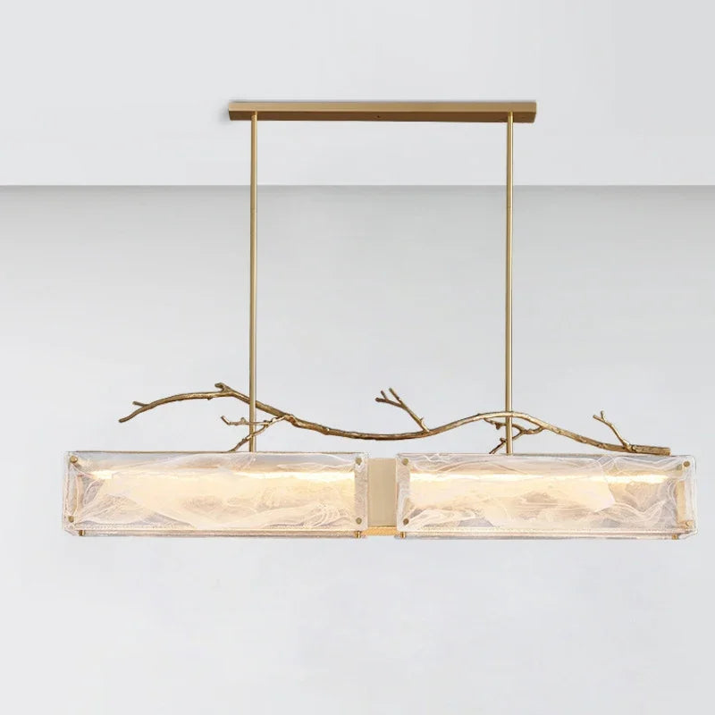 Brushed gold branch glass rectangular pendant light shown illuminated.