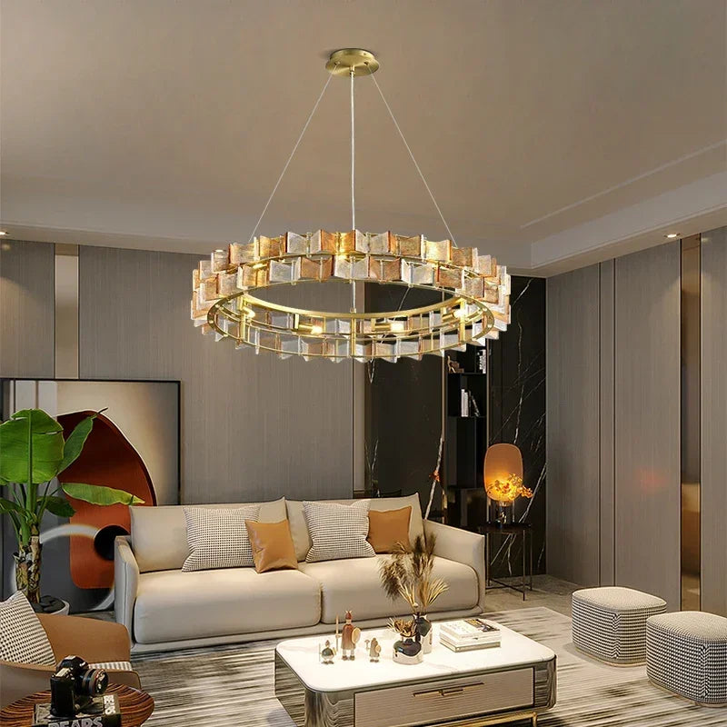A modern living room with a gold ring chandelier featuring amber and clear faceted glass crystals.