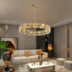 A modern living room with a gold ring chandelier featuring amber and clear faceted glass crystals.