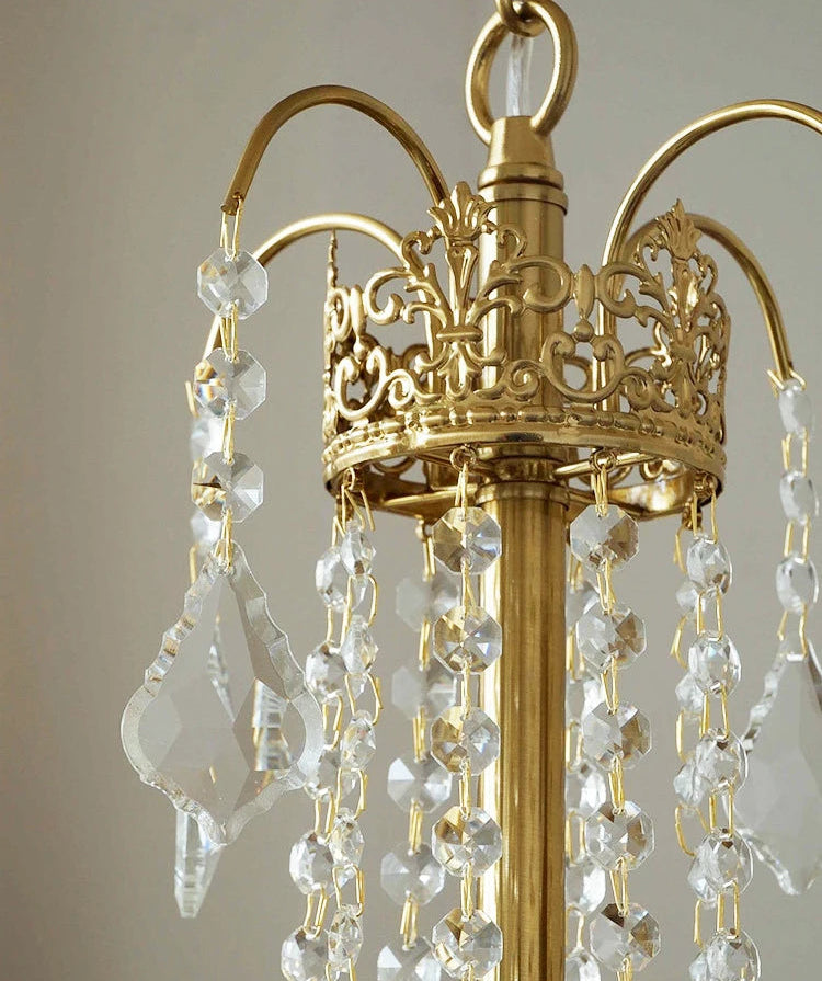 Gold chandelier with crystal beads against a neutral background