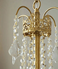 Gold chandelier with crystal beads against a neutral background