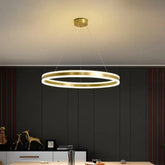 Gold ring pendant light with a polished gold finish, suspended from the ceiling, emitting a warm glow.