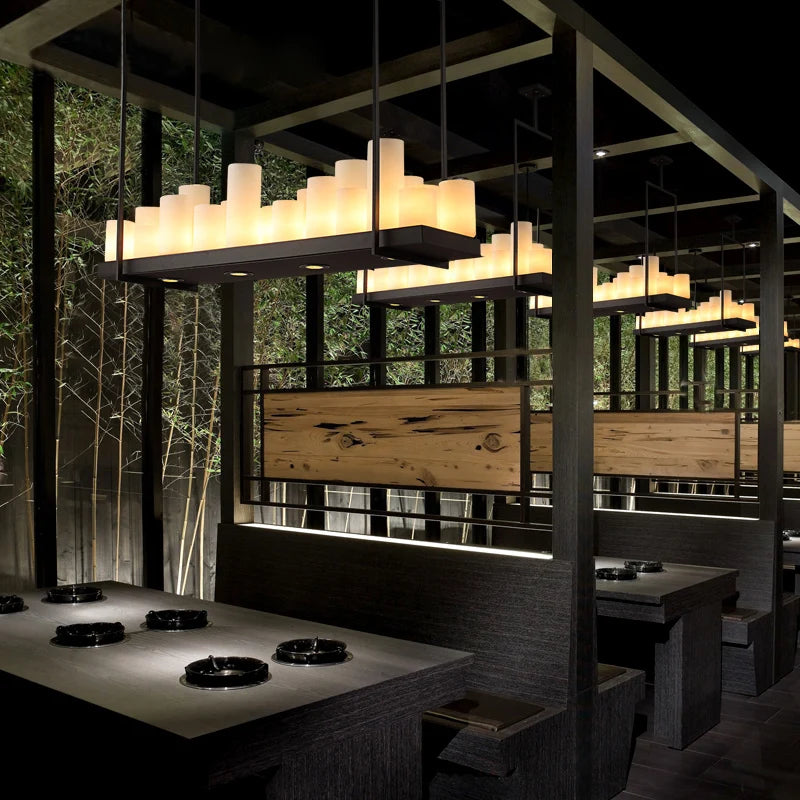 Modern restaurant interior with wooden walls, tables, and pendant lights.